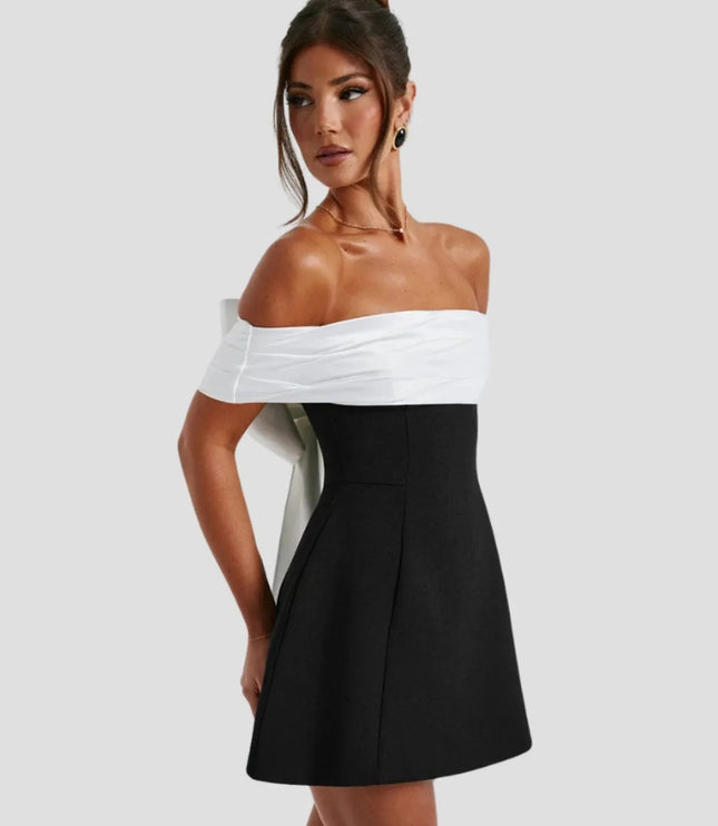 Side profile of black mini dress with structured A-line skirt and off-shoulder top