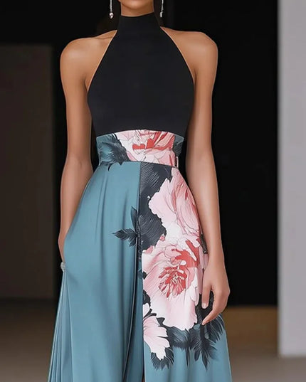 Front view of halter floral maxi dress with red and pink peonies, black leaves, and flowing teal skirt