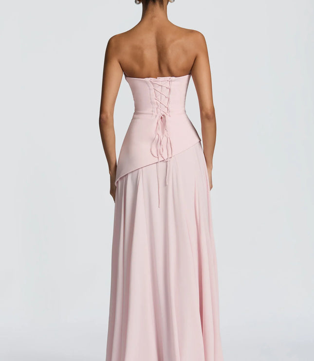 Blush pink strapless maxi dress with lace-up corset back and draped bodice