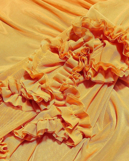 Close-up texture of yellow fabric with orange-toned ruffled trim detail