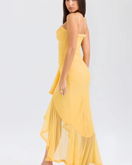 Back view of yellow spaghetti strap maxi dress with flowing ruffled skirt