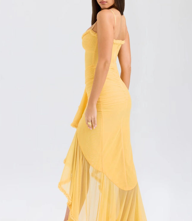 Back view of yellow spaghetti strap maxi dress with flowing ruffled skirt