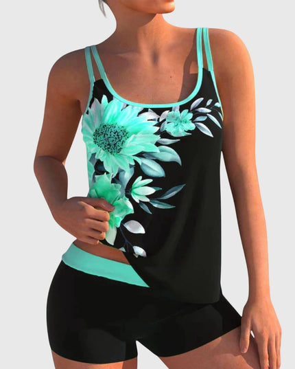 Black tankini top featuring turquoise daisy and floral print with cyan trim and black shorts