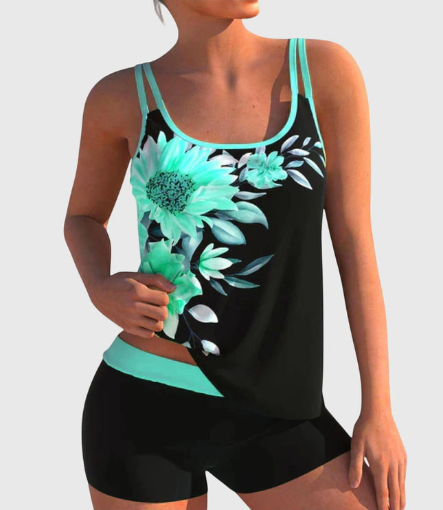 Black tankini top featuring turquoise daisy and floral print with cyan trim and black shorts