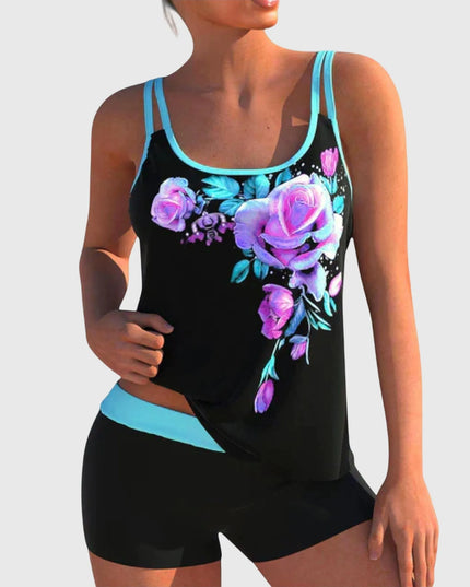 Black tankini top with purple and magenta floral print and turquoise trim paired with black shorts