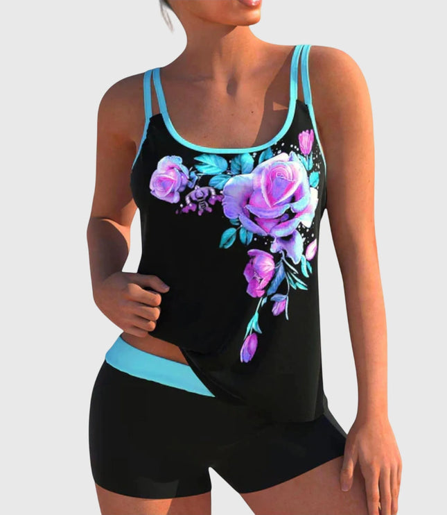 Black tankini top with purple and magenta floral print and turquoise trim paired with black shorts