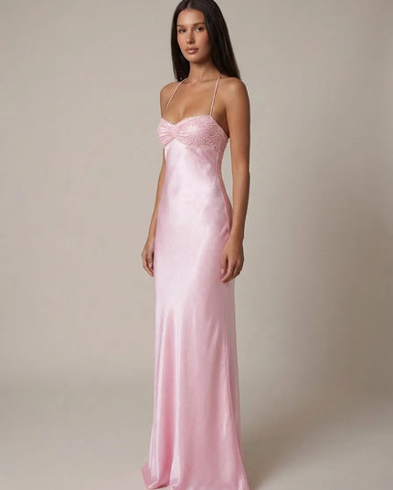 Front angled view of pink halter maxi dress with beaded bust and satin silhouette