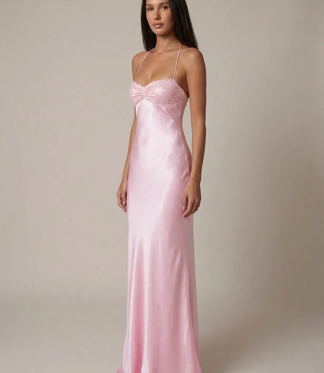 Front angled view of pink halter maxi dress with beaded bust and satin silhouette
