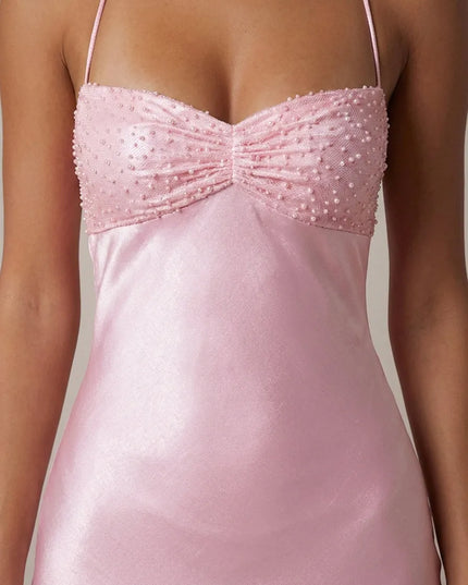 Close back view of pink satin maxi dress with crisscross halter straps and tie-back closure