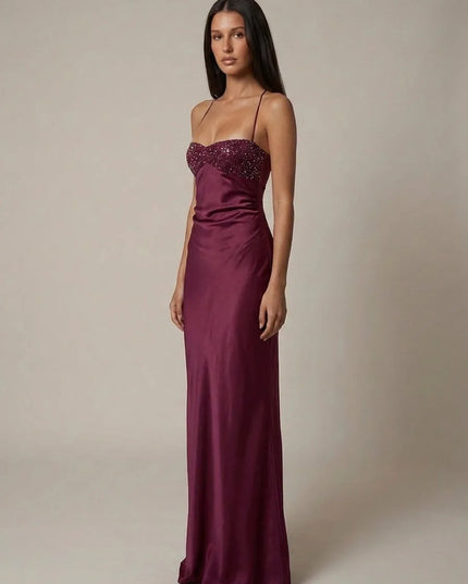 Front view of burgundy beaded halter maxi dress with satin skirt and fitted column silhouette