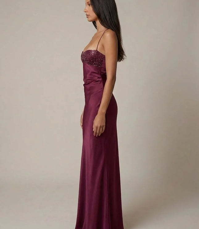Side view of burgundy halter maxi dress with sparkling beaded bust and smooth satin finish
