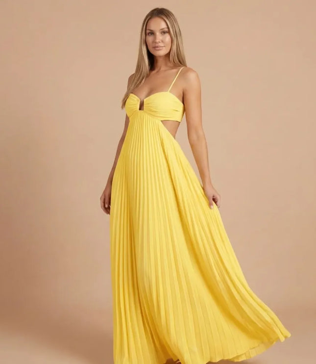 Front angled view of bright yellow pleated halter maxi dress with side cutouts and flowing skirt