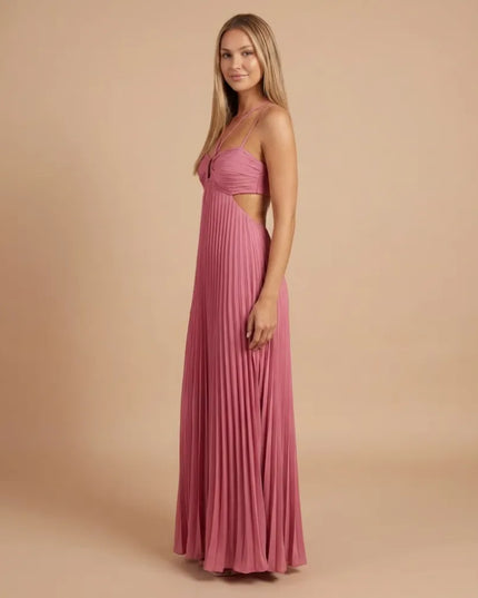 Side angled view of pink pleated halter maxi dress with long flowing skirt and open waist