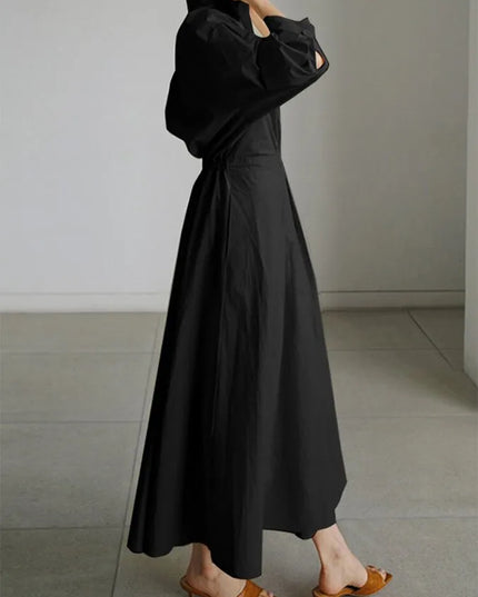 Side view of black puffed sleeve wrap dress showing dramatic sleeve volume