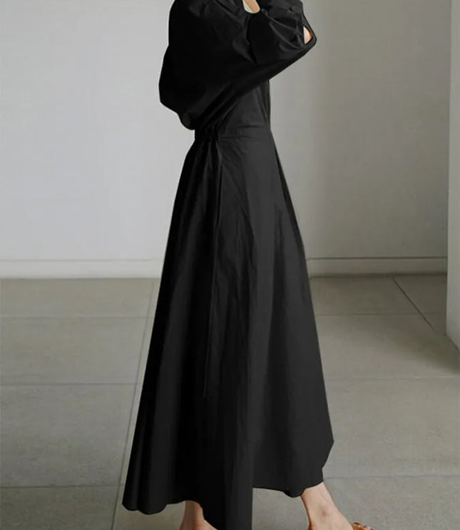 Side view of black puffed sleeve wrap dress showing dramatic sleeve volume