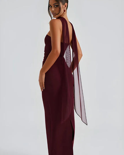 Side back view of burgundy strapless dress with flowing sheer scarf overlay