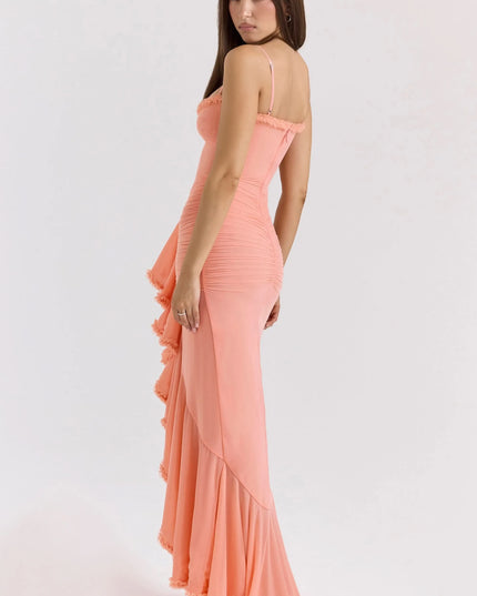 Side view of coral maxi dress with sweetheart neckline, thin straps, and ruffled front drape