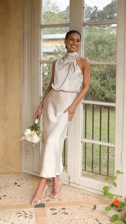 Cream halter midi dress with twisted neckline and flowing skirt