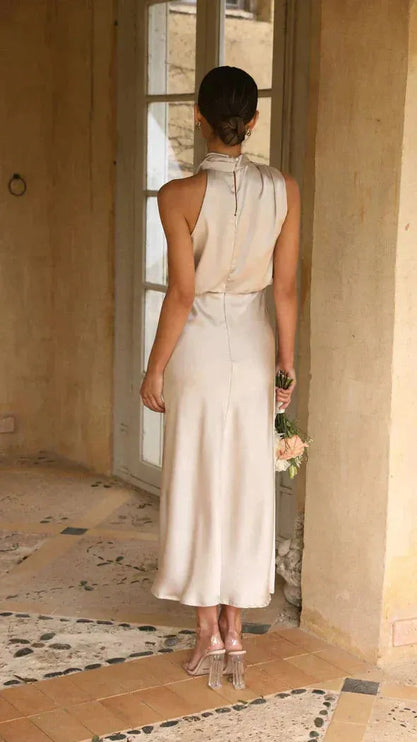Back view of cream sleeveless halter dress with button closure