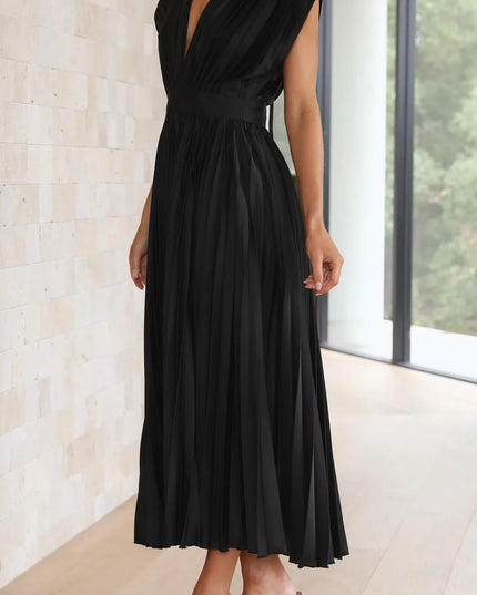 Side profile of black pleated midi dress showing high waist definition