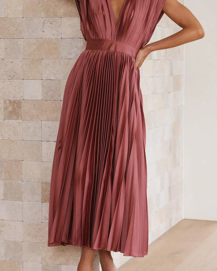 Side view of mauve pleated midi dress showing v-neckline and flowing skirt