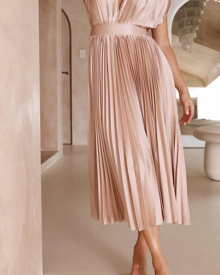 Three-quarter view blush pink pleated midi dress with v-neck and high waistline