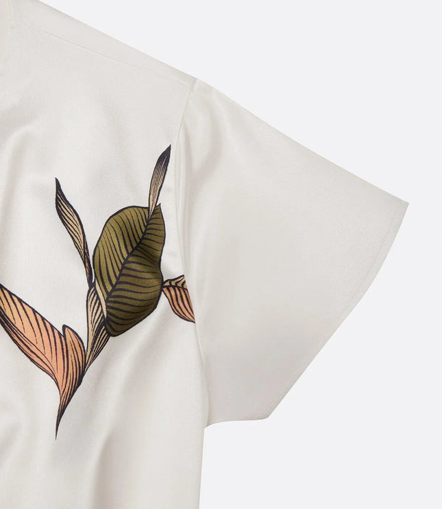 Close-up of olive and coral striped leaf print on cream fabric