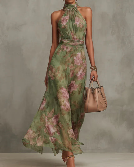 Women floral halter maxi dress in green with pink print, front view with flowing skirt and handbag
