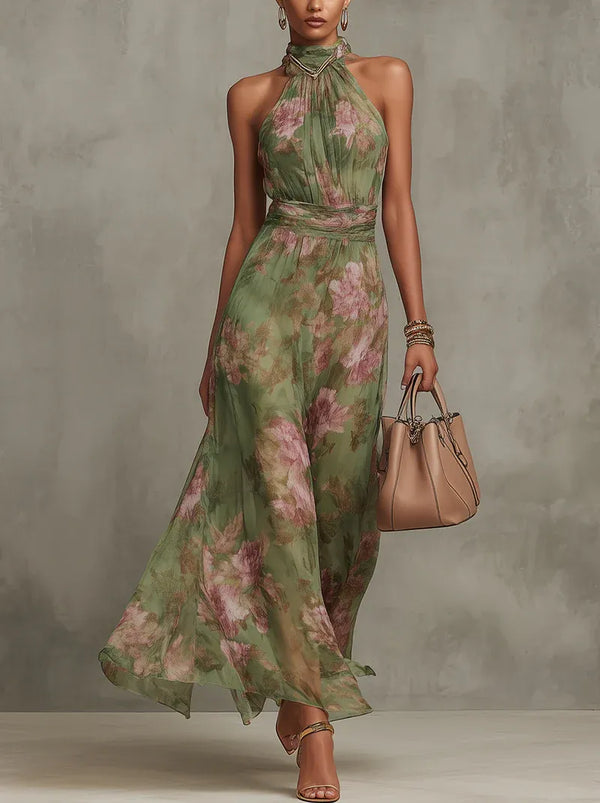 Women floral halter maxi dress in green with pink print, front view with flowing skirt and handbag