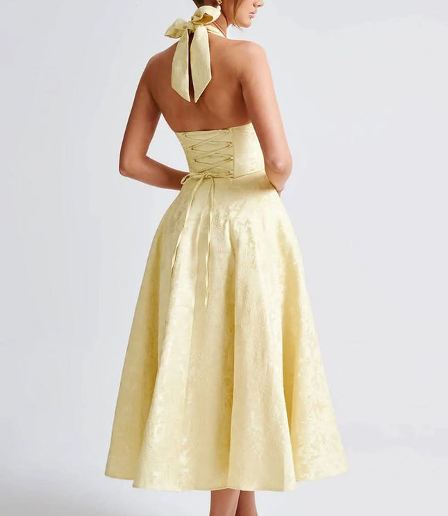 Back view of pale yellow floral halter midi dress with open back and lace-up corset detail