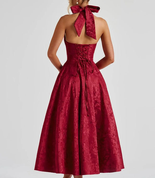 Back view of deep red floral halter midi dress with bow tie neck and lace-up back