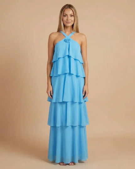 Front view of blue halter tiered maxi dress with layered ruffles and rosette detail