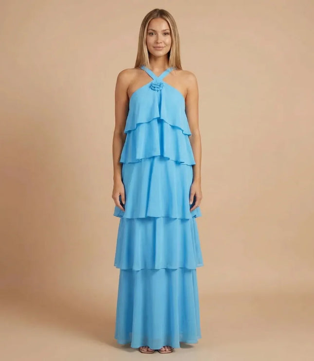 Front view of blue halter tiered maxi dress with layered ruffles and rosette detail